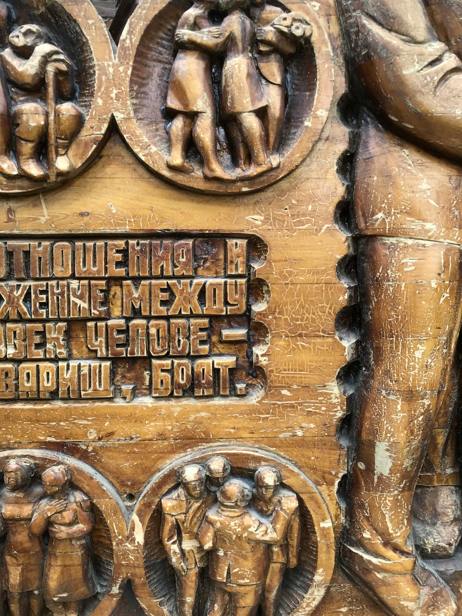 Carved wooden panel with embracing figures reliefs and Cyrillic text