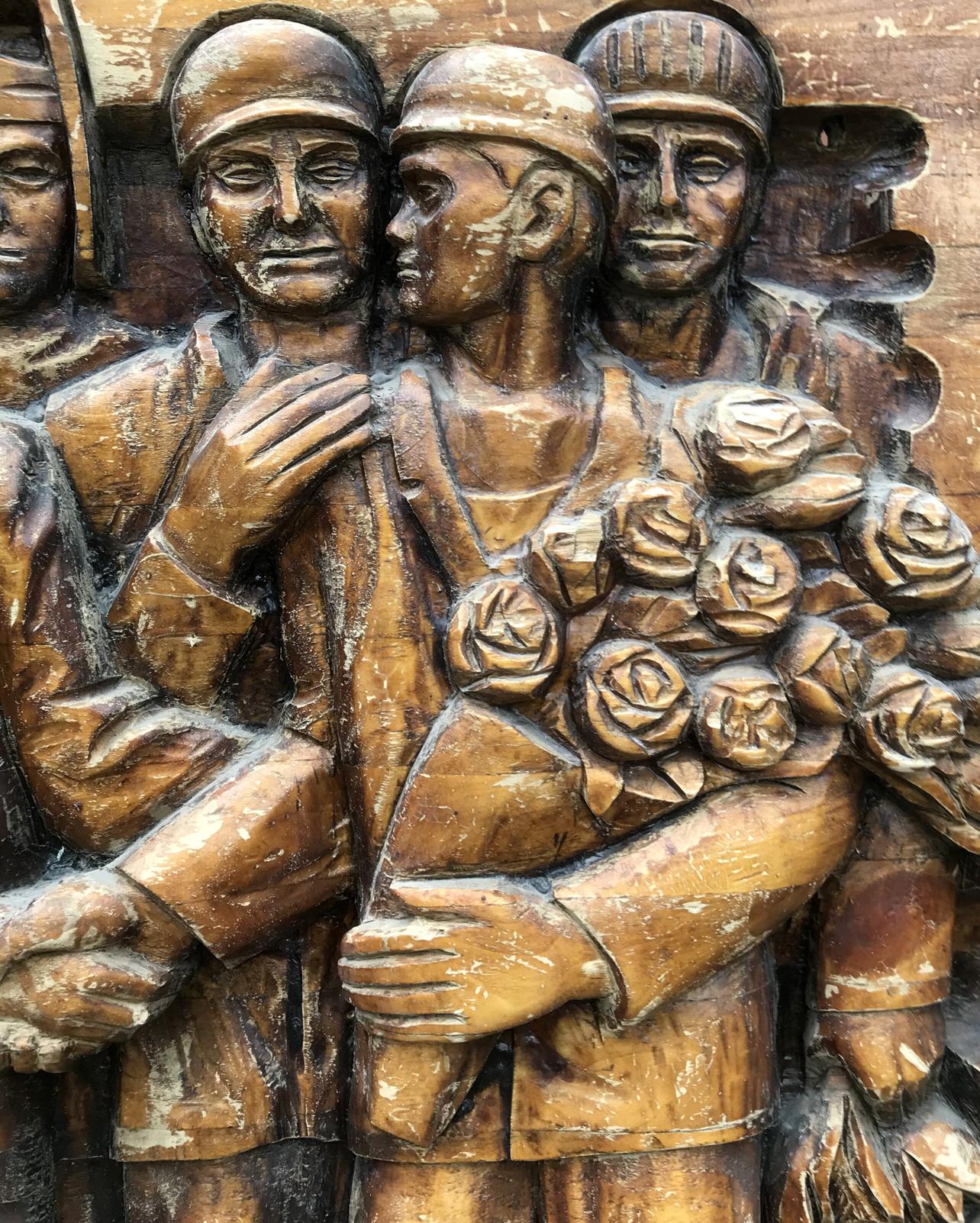 Detailed wooden relief of three soldiers with roses, social realism art
