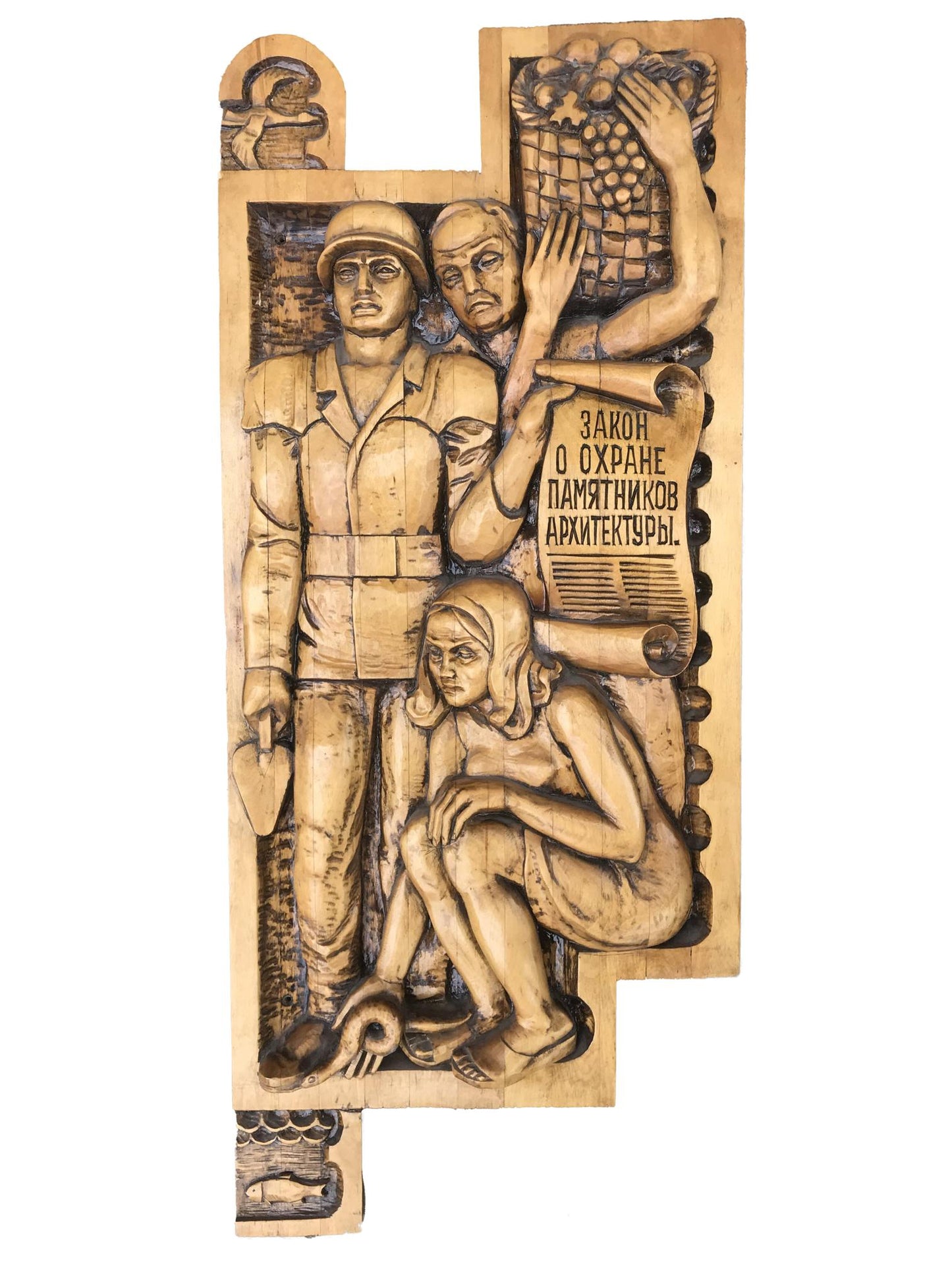 Light wooden relief of three figures with Cyrillic text, social realism architectural monuments law
