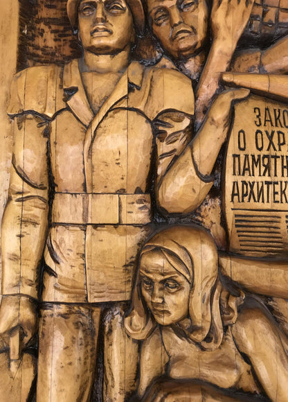 Detailed wooden relief of three somber figures in Social realism Law on the Protection of Architectural Monuments