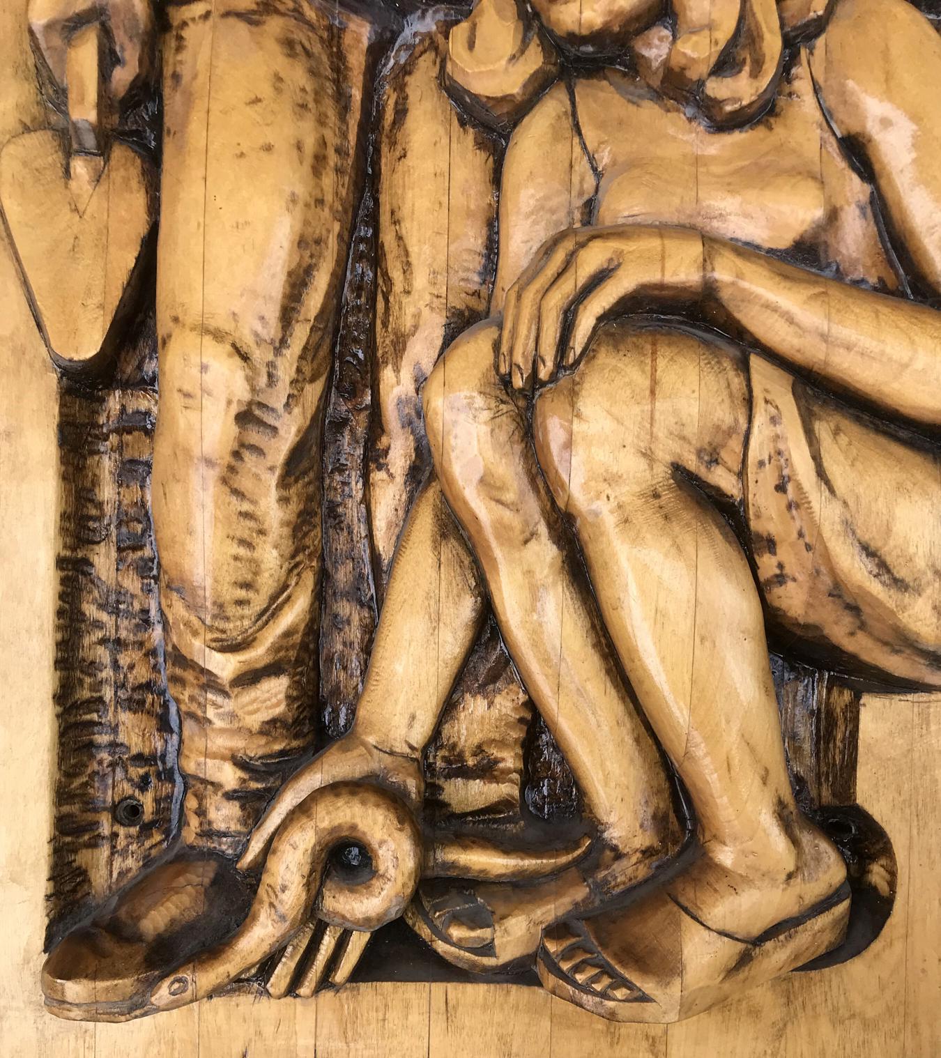 Detailed wood carving of seated Social realism figure in warm tones