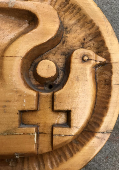 Carved wooden dove cookie mold with intricate grooves and cross motif