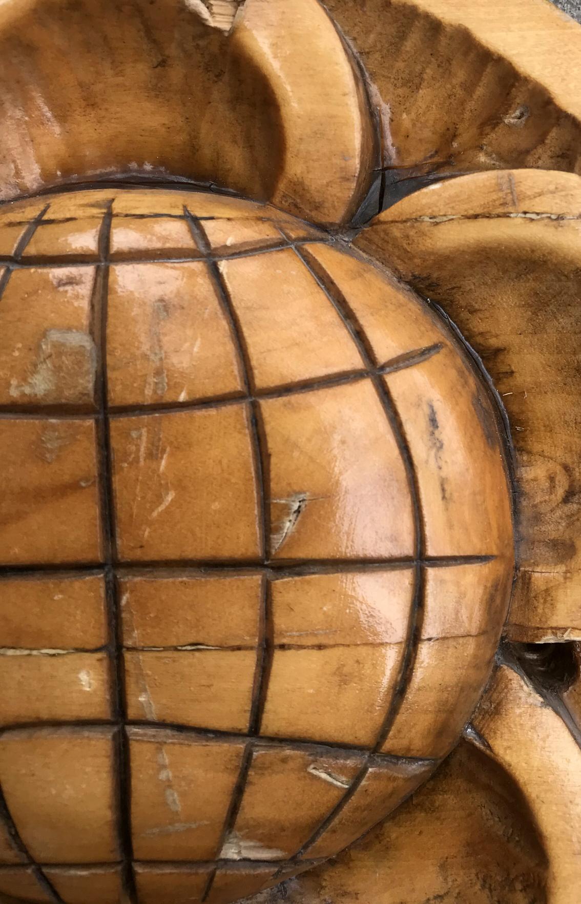 Carved wooden globe with grid, sunburst, social realism science design