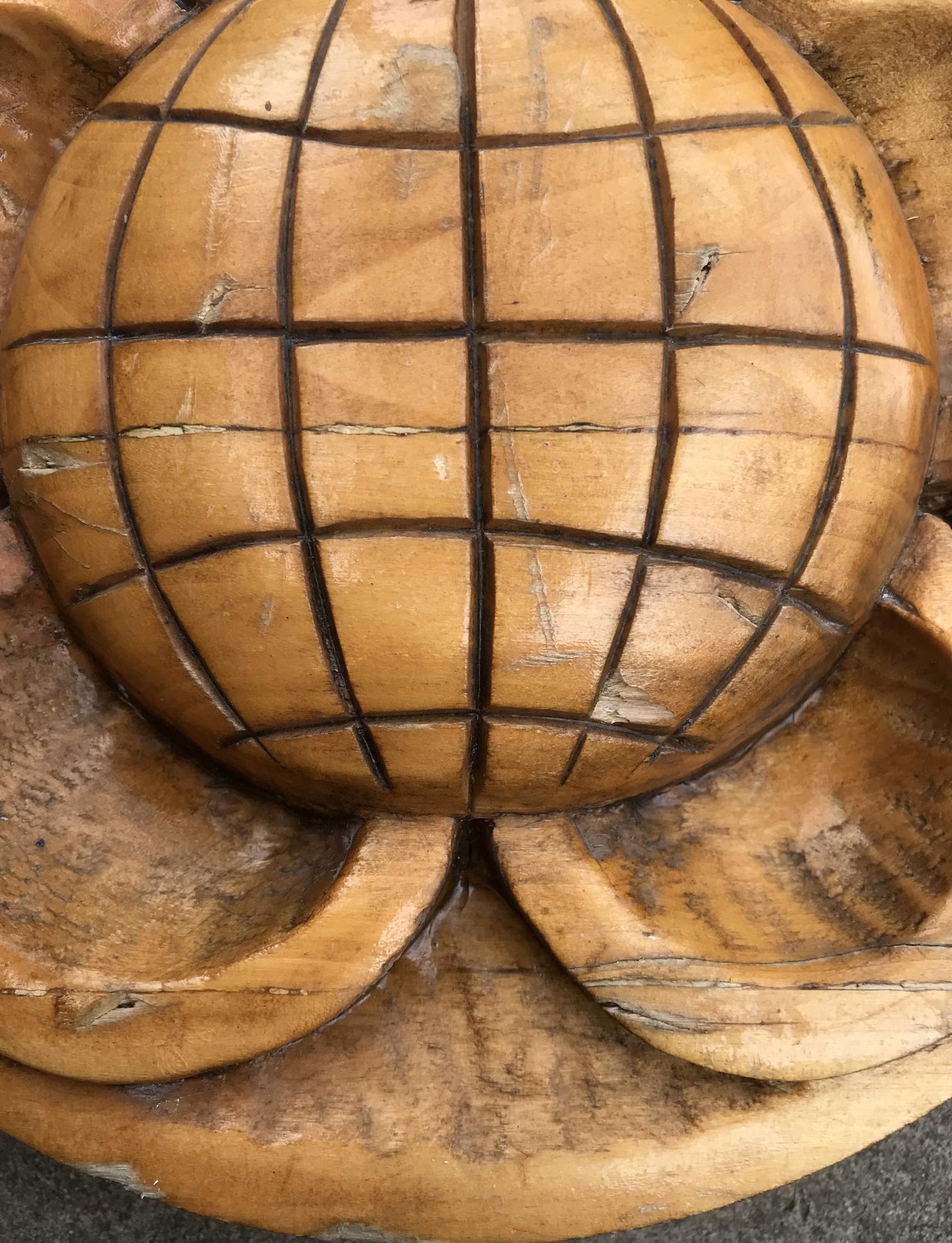 Carved wooden globe with grid pattern in warm amber tones
