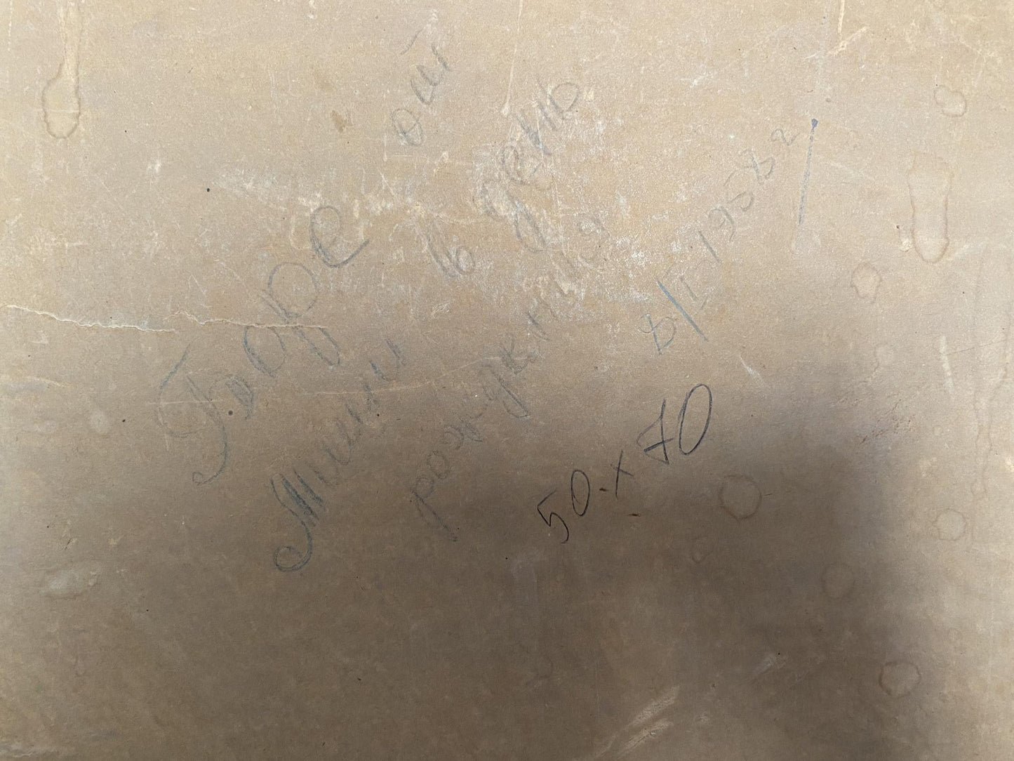 Back of beige marble slab with faint engraved Oil painting Rocky coast Strelov Arkady Efimovich text and circular patterns