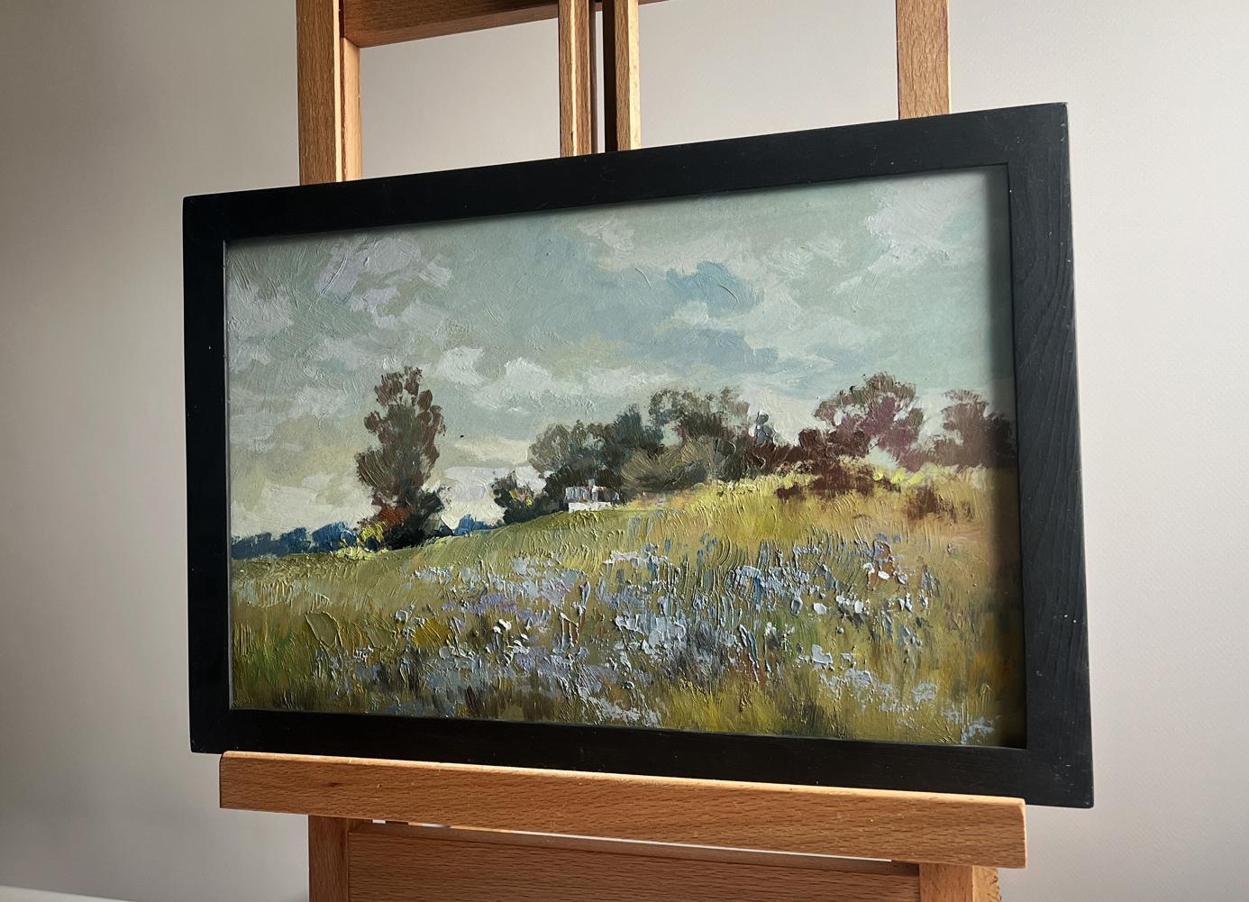 Black-framed oil painting of sunlit summer flower meadow by Yuriy Suprunchuk