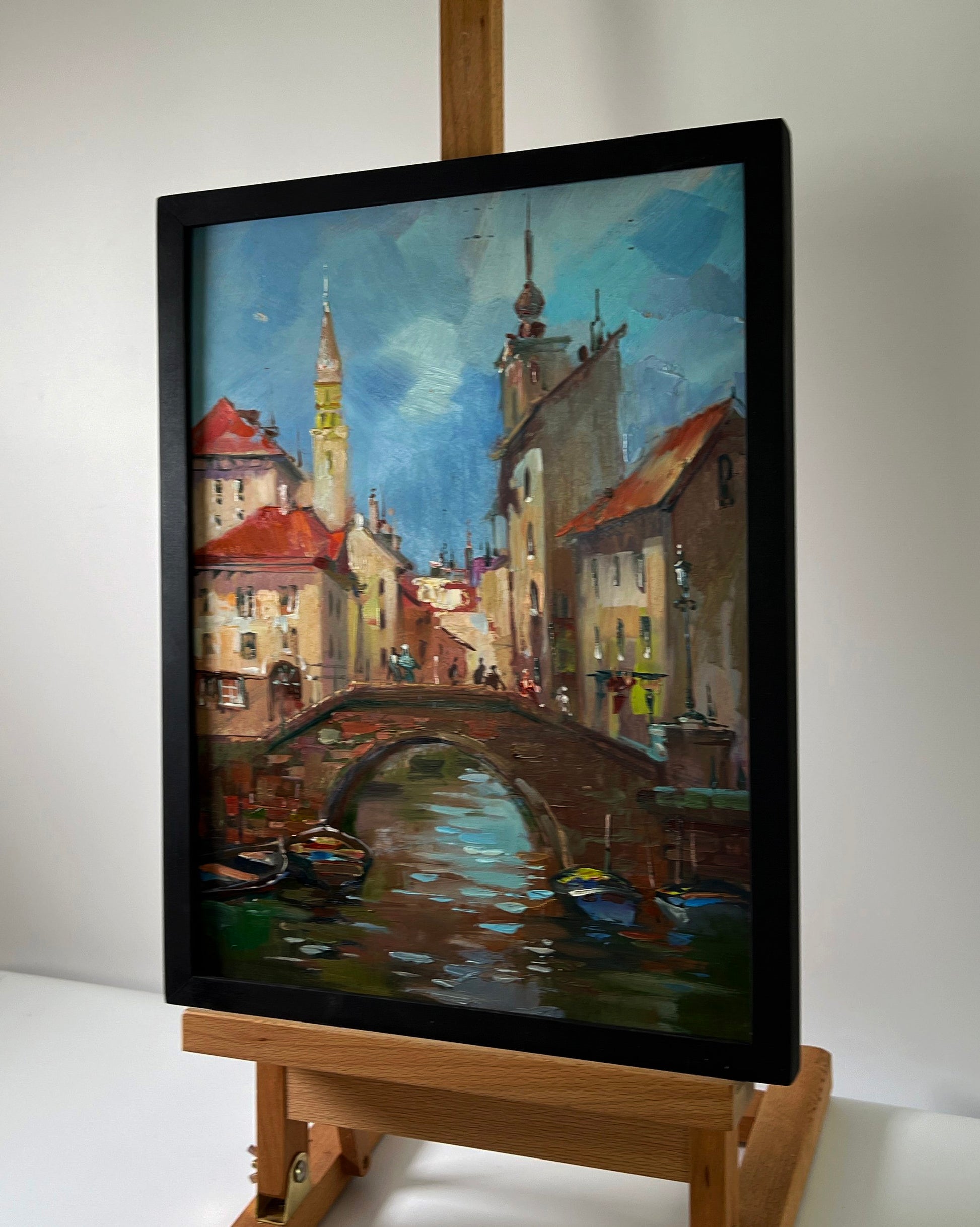 Oil painting of European canal city with river by Yuriy Suprunchuk in black frame