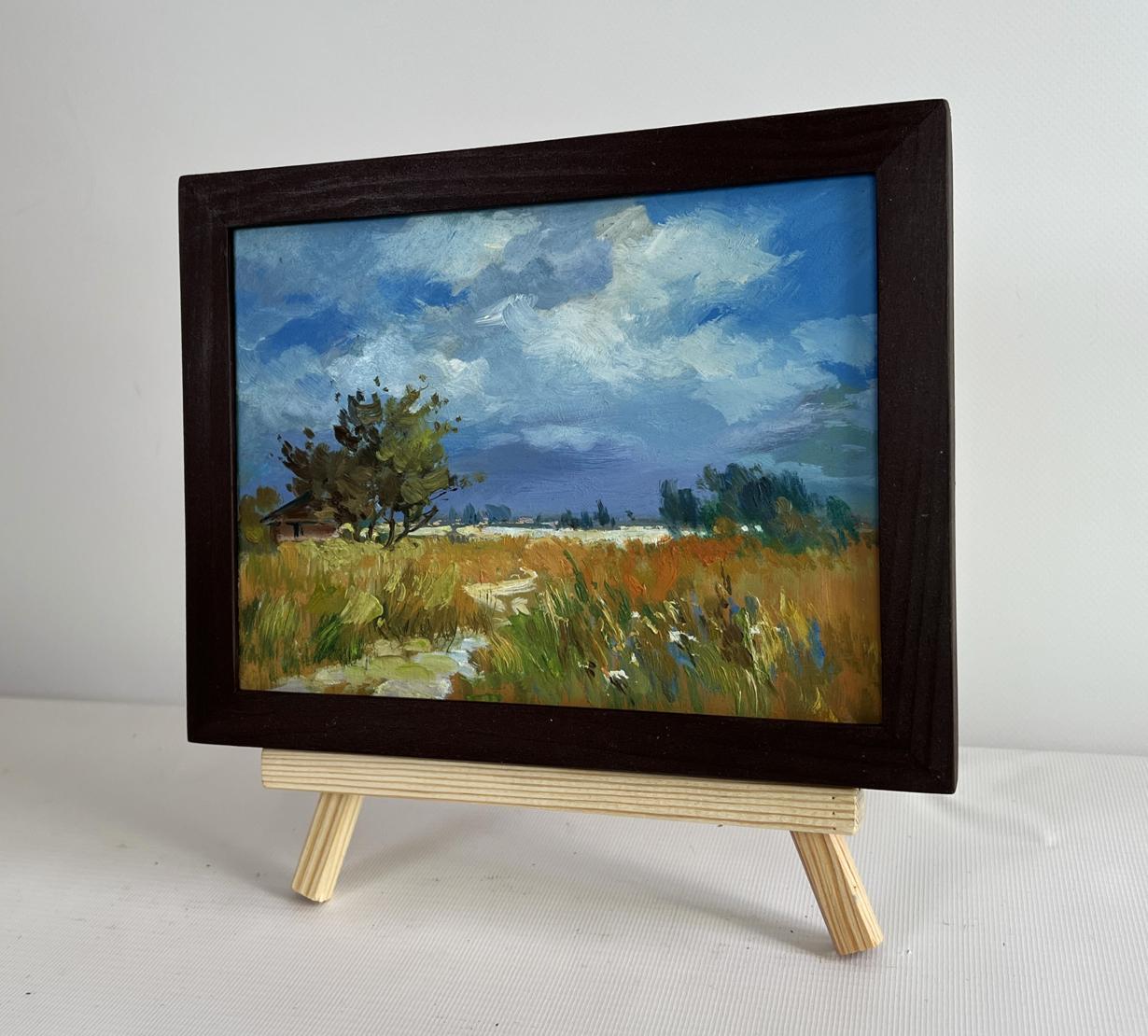 Framed oil painting of sun shining through clouds in pastoral landscape by Yuriy Suprunchuk