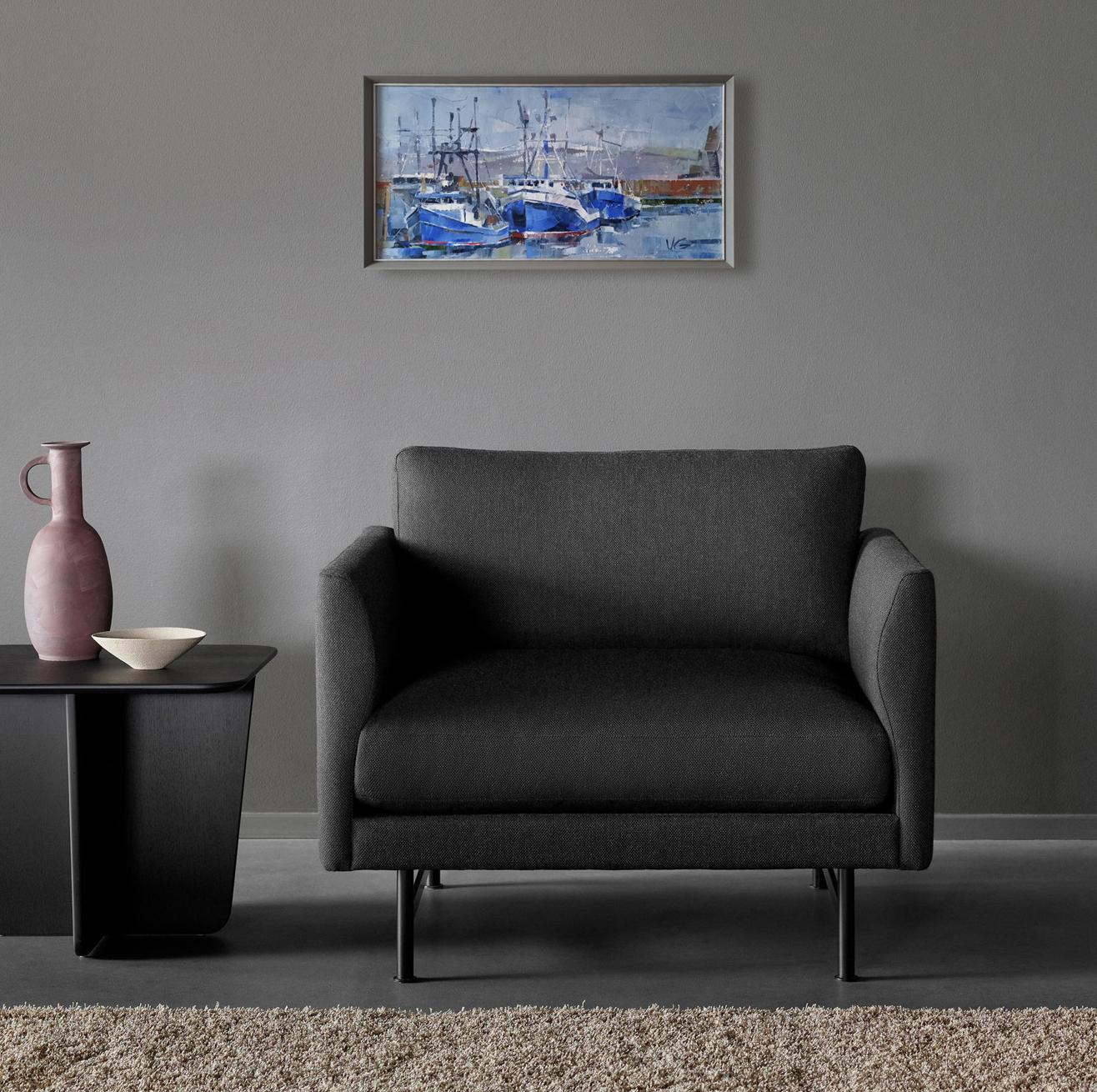 Dark gray upholstered armchair with black legs beside Oil painting Seagulls Volodymyr Gluhomanyuk