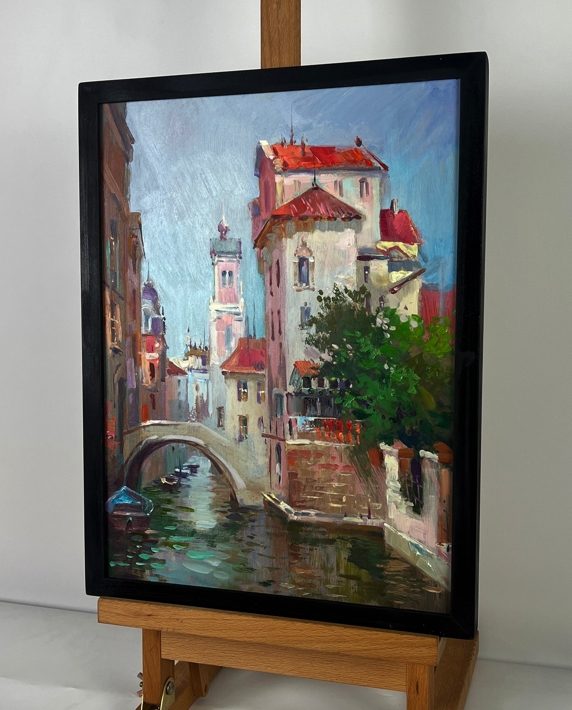 Framed oil painting of European canal by Yuriy Suprunchuk in black frame