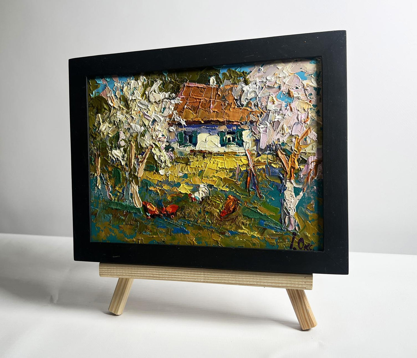 Oil painting of flowering trees in garden by Oksana Ivanyuk in black frame