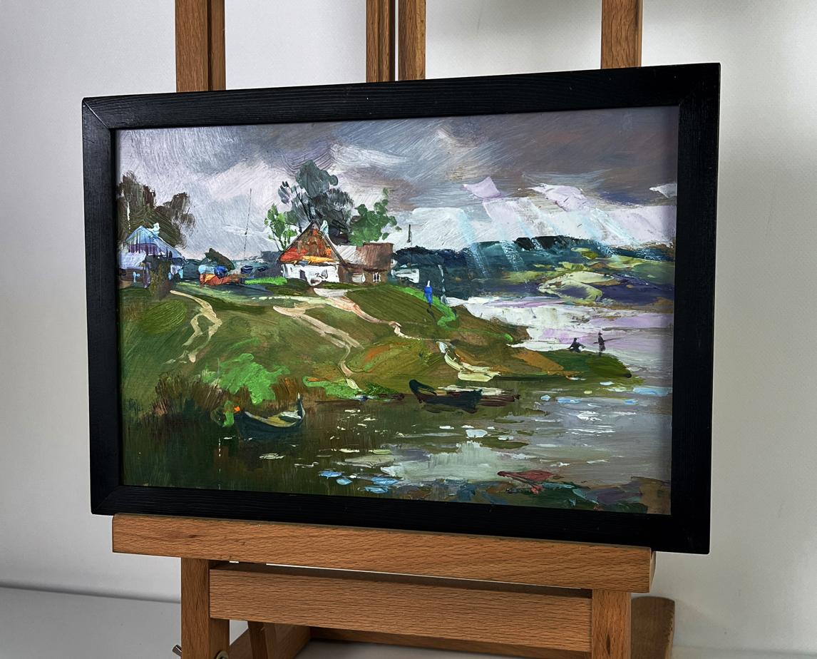Black-framed oil painting of river near village by Yuriy Suprunchuk