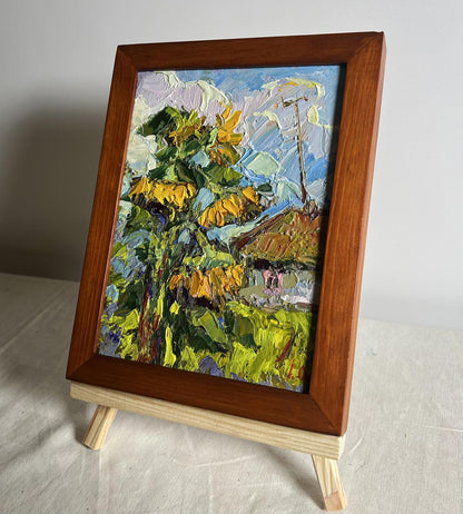Vibrant impressionist oil painting of sunflowers near the house by Oksana Ivanyuk in wooden frame
