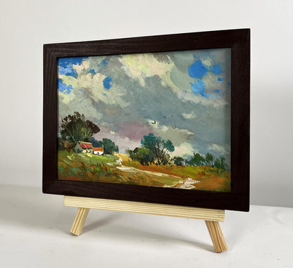 Dark wooden-framed oil painting of overcast village sky by Yuriy Suprunchuk