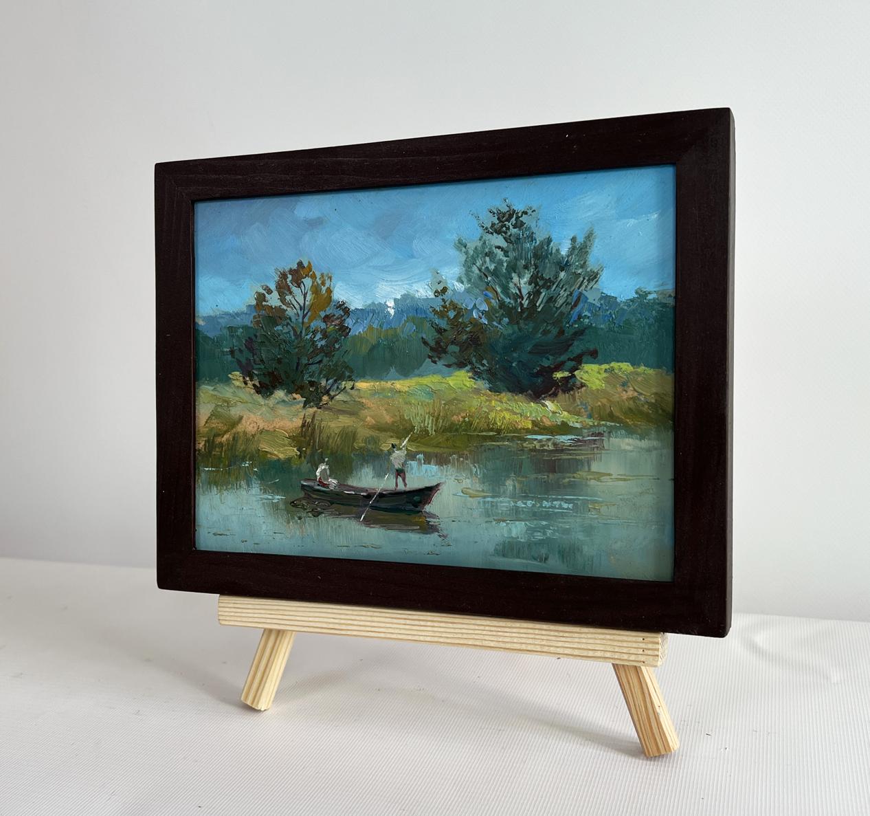 Framed oil painting by Yuriy Suprunchuk of two people sailing on serene river with trees