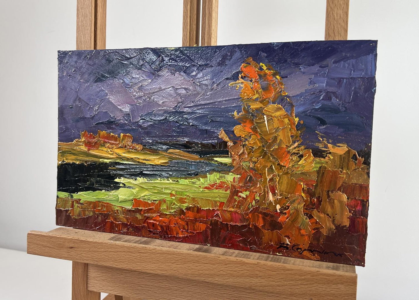 Vibrant impressionist oil painting of autumn river landscape by Boris Serdyuk on easel