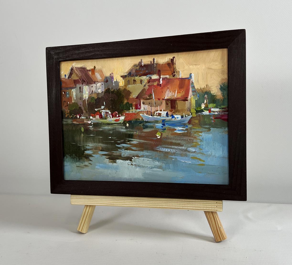 Framed oil painting of sunset glow over harbor rooftops by Yuriy Suprunchuk