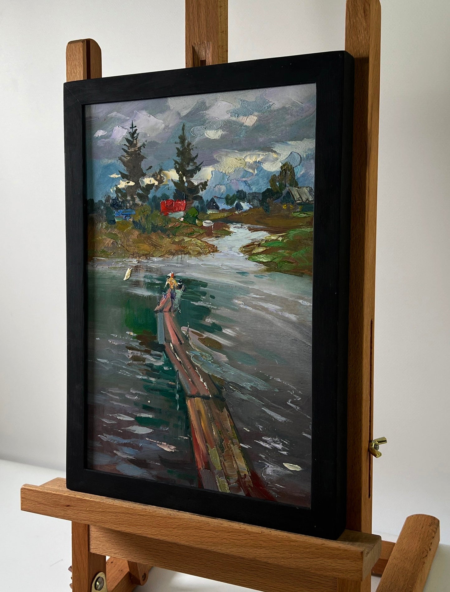 Framed oil painting of girl on river bridge by Yuriy Suprunchuk on wooden easel