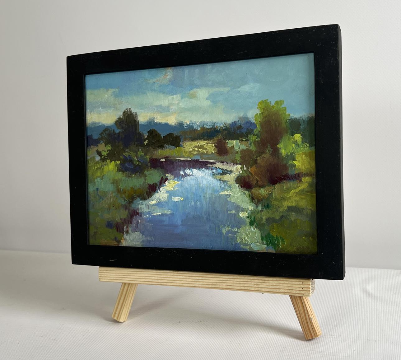 Oil painting of sunset clouds over river by Yuriy Suprunchuk on easel
