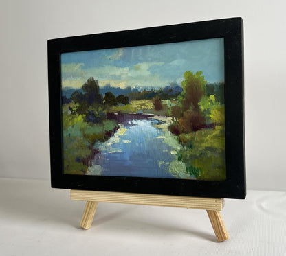 Oil painting of sunset clouds over river by Yuriy Suprunchuk on easel