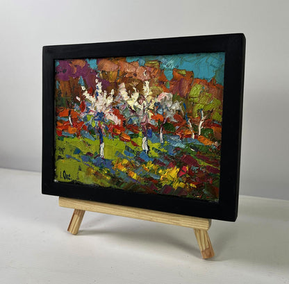 Oil painting of flowering trees in garden by Oksana Ivanyuk in black frame