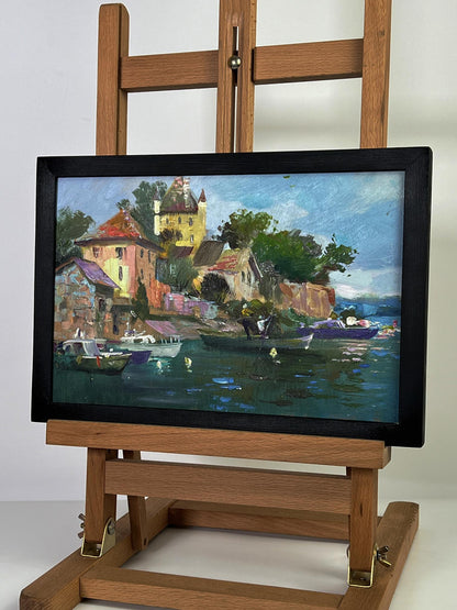 Framed oil painting of colorful coastal village with boats by Yuriy Suprunchuk