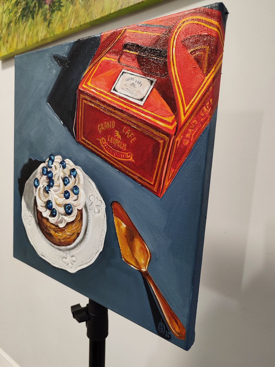 Oil painting of vibrant red gold Grand Café Lebon cake box on desert table by Oksana Sklym