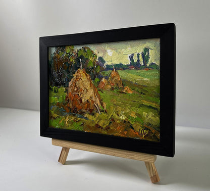Oil painting Haystacks in the field by Oksana Ivanyuk in black frame