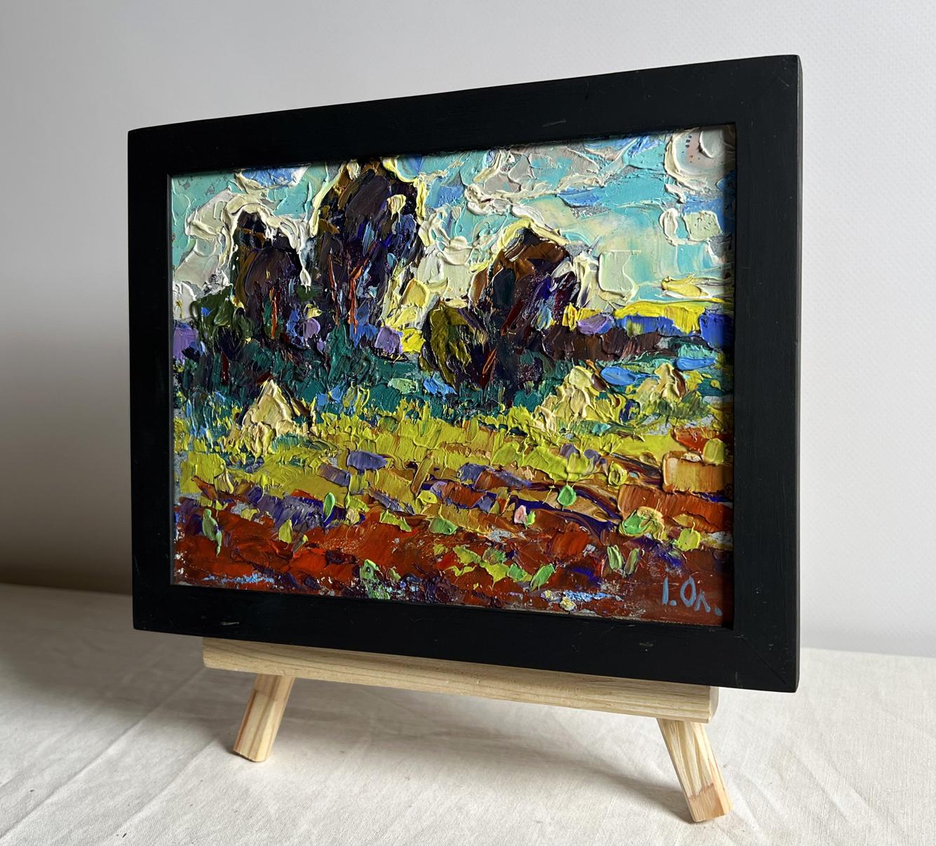 Oil painting of plowed field and haystacks by Oleksiy Ivanyuk in black frame