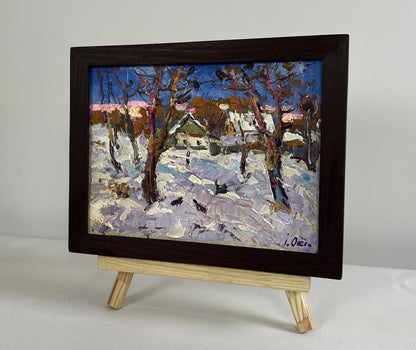 Oil painting by Oksana Ivanyuk: snowy village with crows in bare trees, framed