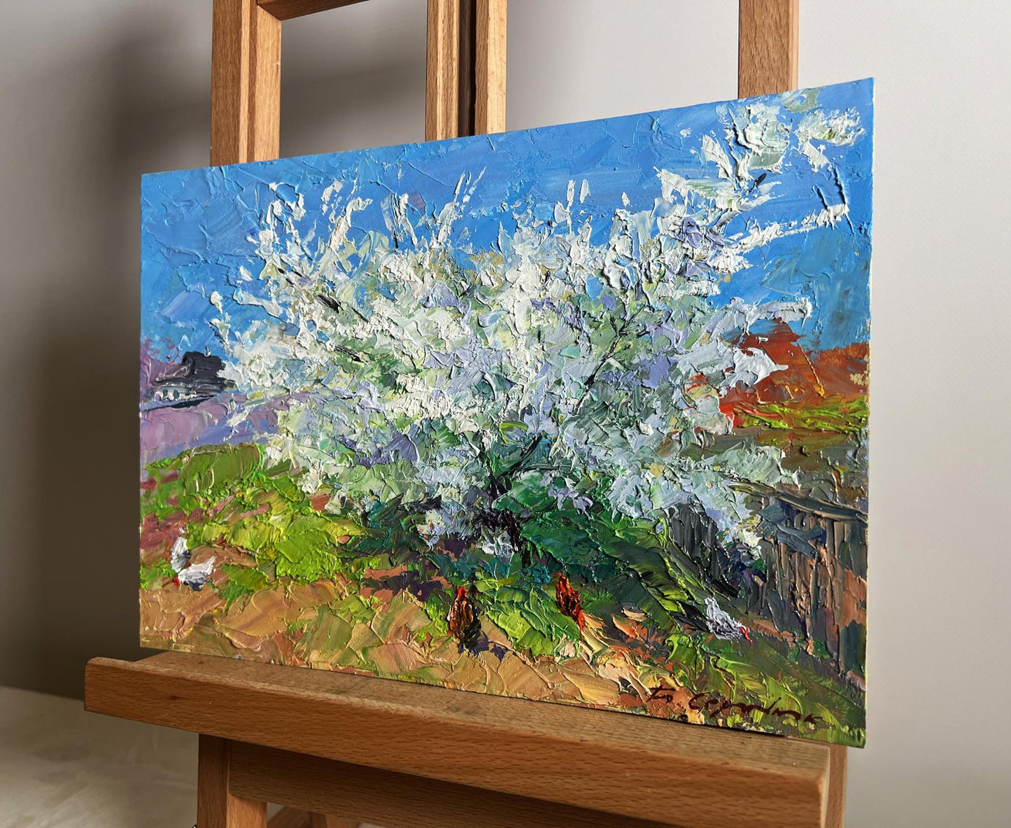Vibrant impressionist oil painting of flowering tree and chickens by Boris Serdyuk on easel