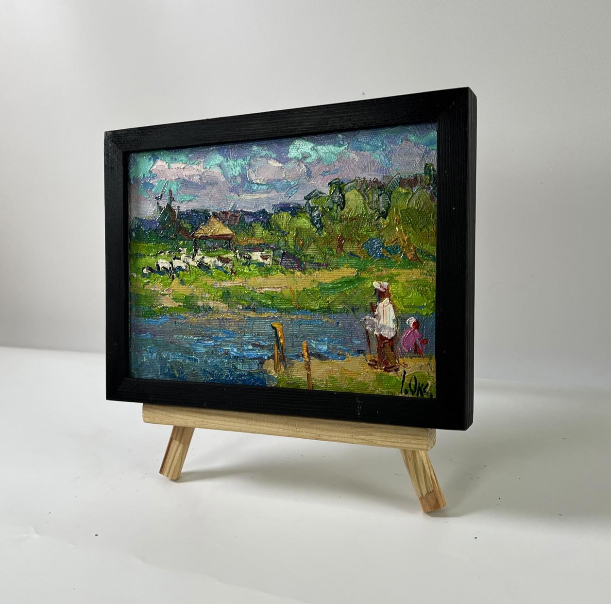 Oil painting By the Summer River by Oksana Ivanyuk in black frame on easel