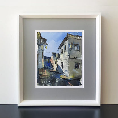Framed oil painting by Volodymyr Gluhomanyuk of narrow street with white buildings