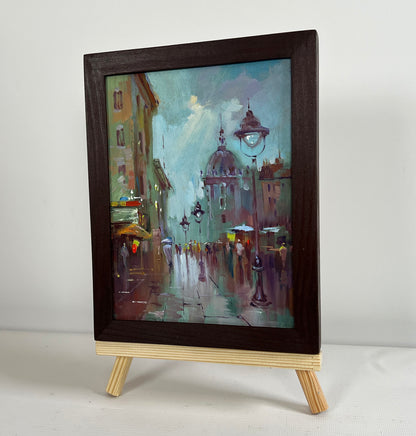 Dark wood-framed oil painting of rainy city street by Yuriy Suprunchuk