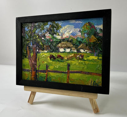 Vibrant impressionist oil painting by Oksana Ivanyuk: cows grazing in green meadow, framed