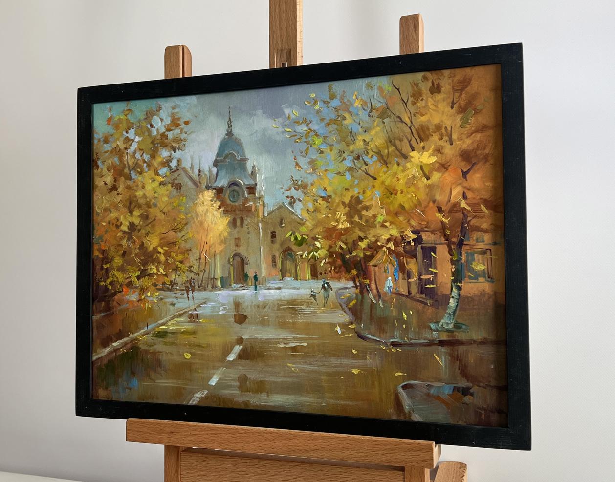 Oil painting Autumn in the heart of the city by Yuriy Suprunchuk in black frame on easel