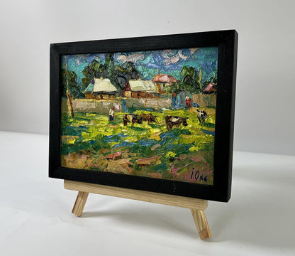 Oil painting by Oksana Ivanyuk: cows graze in vibrant rural fields