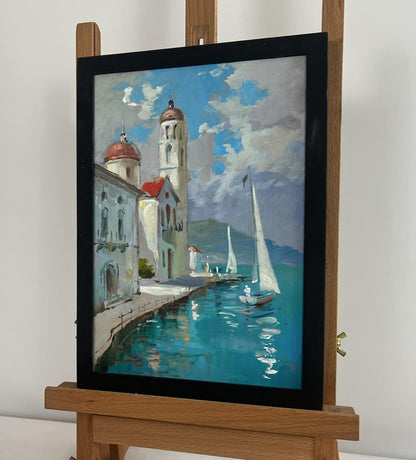 Framed oil painting by Yuriy Suprunchuk: coastal city with white buildings, red domes, sailboats on turquoise water