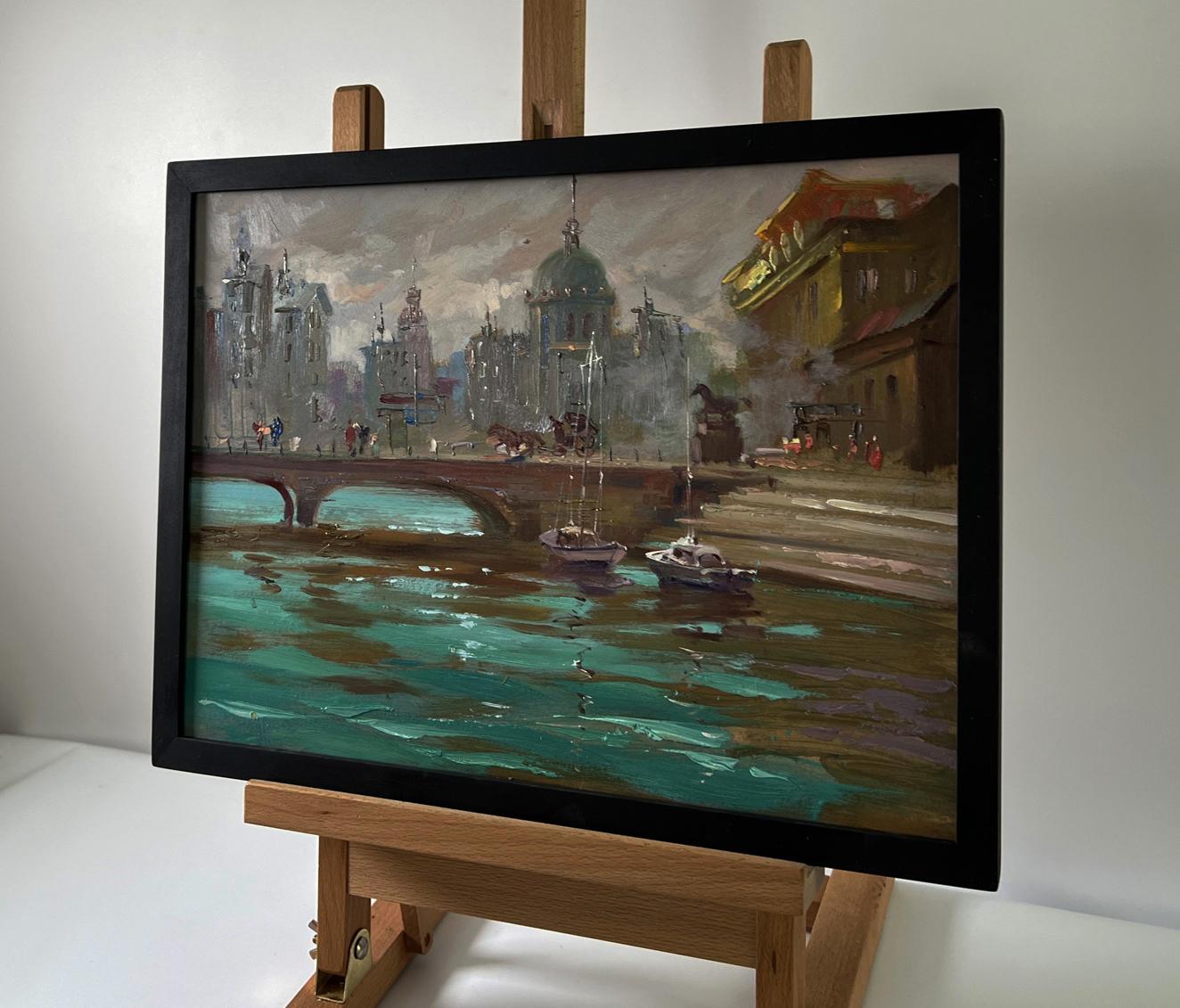 Oil painting of busy city streets with teal water by Yuriy Suprunchuk in black frame