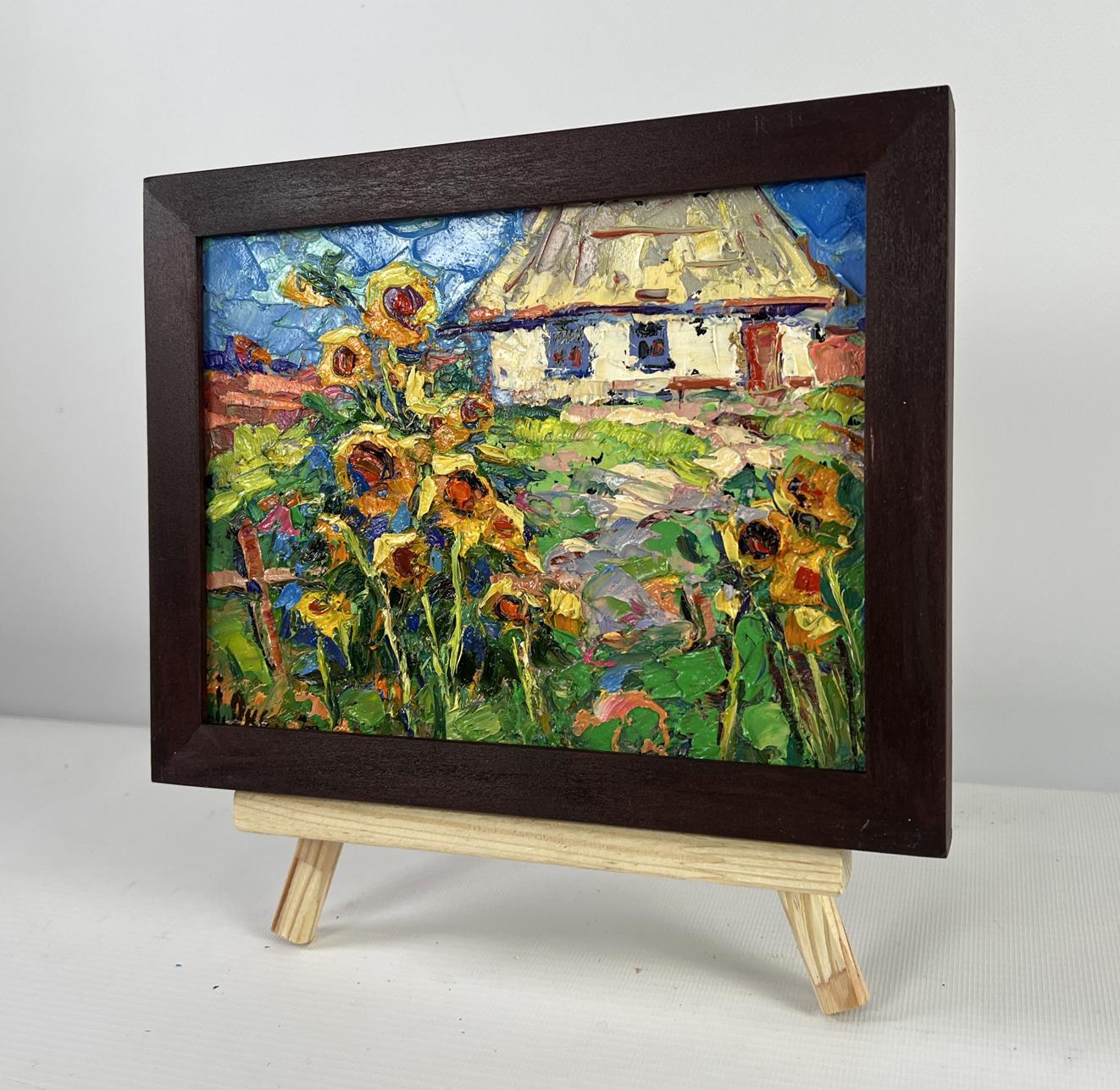 Vibrant impressionist oil painting of sunflowers and cottage by Oksana Ivanyuk in wooden frame