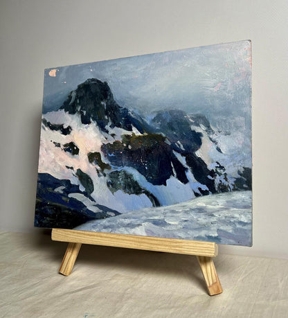 Oil painting of snowy mountain peak by Tatyana Derdey on wooden easel