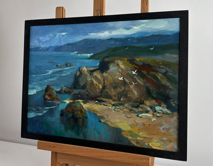 Framed oil painting of sunlight through clouds on coastal cliffs by Yuriy Suprunchuk