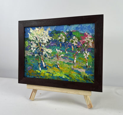 Vibrant impressionist oil painting of blooming spring garden by Oksana Ivanyuk on easel