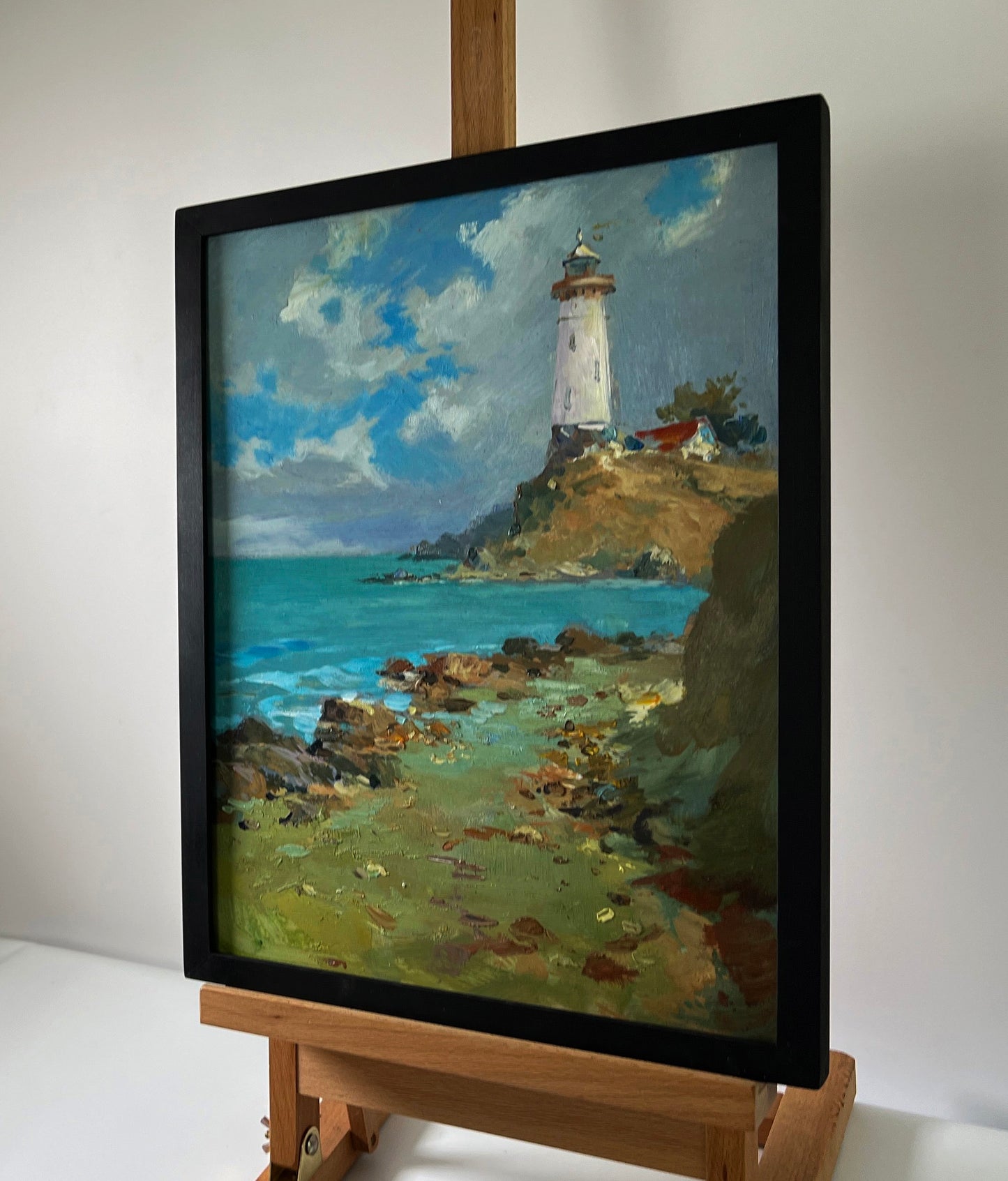 Oil painting Coast with a lighthouse by Yuriy Suprunchuk: white lighthouse on cliff