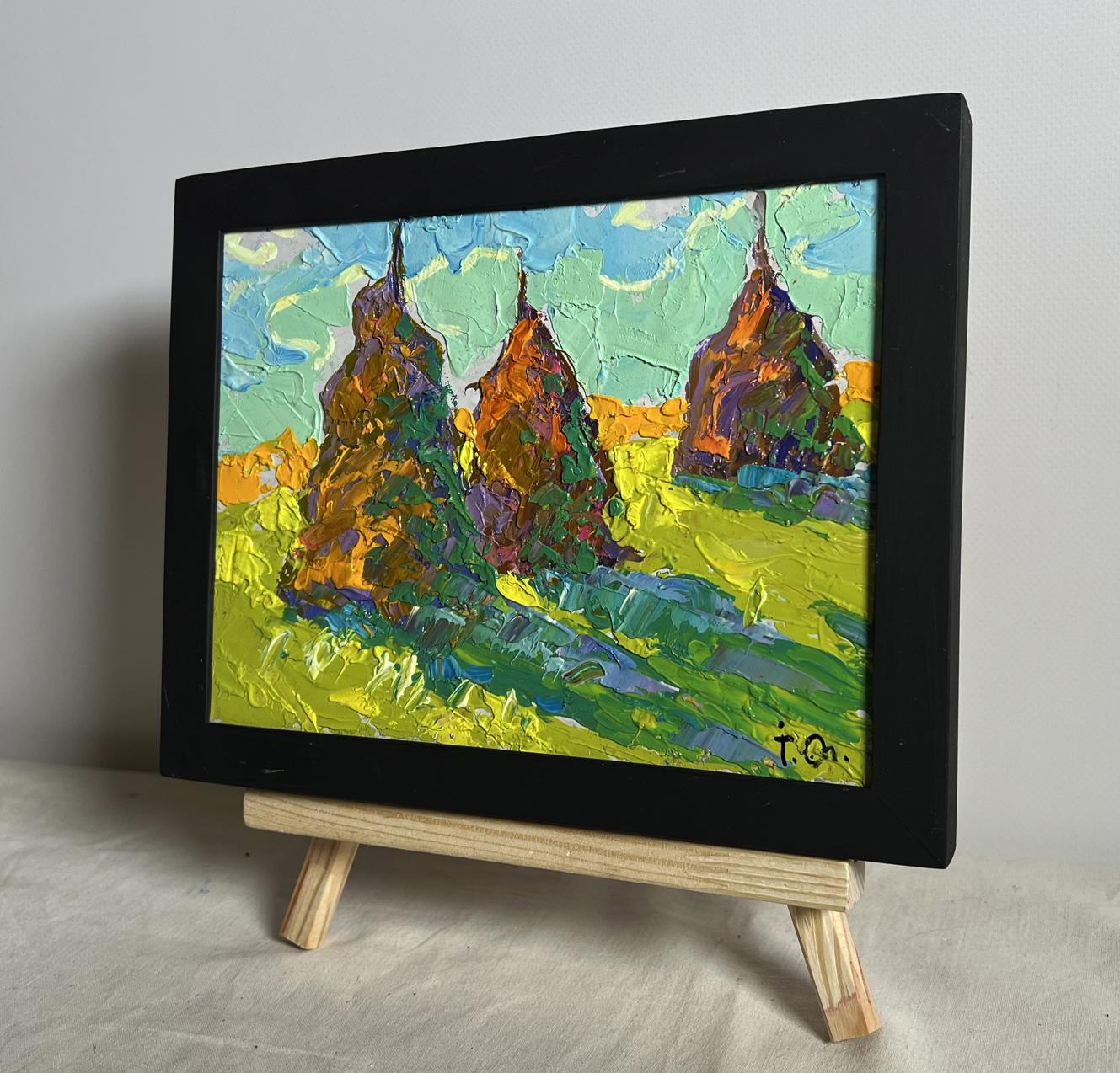 A vibrant, textured oil painting in a sleek black frame depicting three stylized haystacks against a bright sky and green field.
