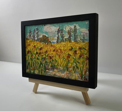 Vibrant oil painting of sunflower field by Oleksiy Ivanyuk in black frame on easel