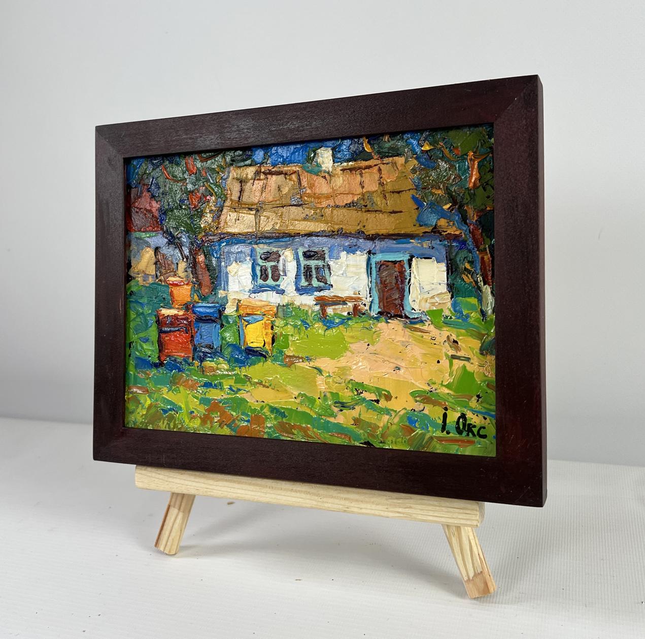 Rustic oil painting of blue white thatched house in greenery by Oksana Ivanyuk