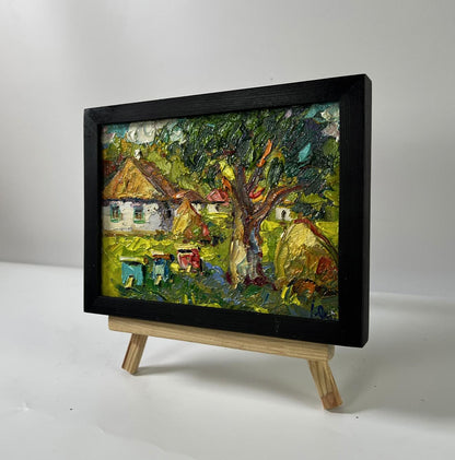 Oil painting of village yard with apiary by Oksana Ivanyuk in black frame