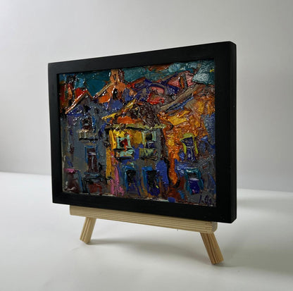 Oil painting The city in night lights by Oleksiy Ivanyuk in black frame on easel