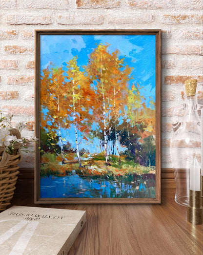A framed painting of autumn trees with vibrant orange and yellow leaves against a bright blue sky, set within a simple wooden frame.